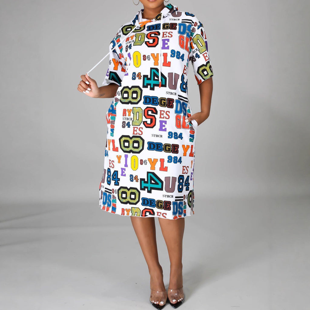Model wearing a white hooded midi dress with colorful letter and number prints and side pockets